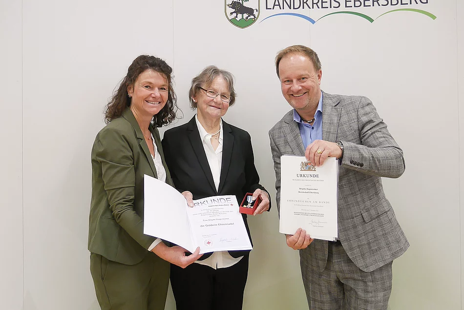 Drei Menschen bei Ehrung