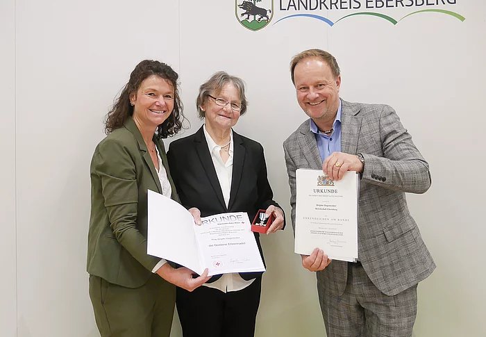 Drei Menschen bei Ehrung