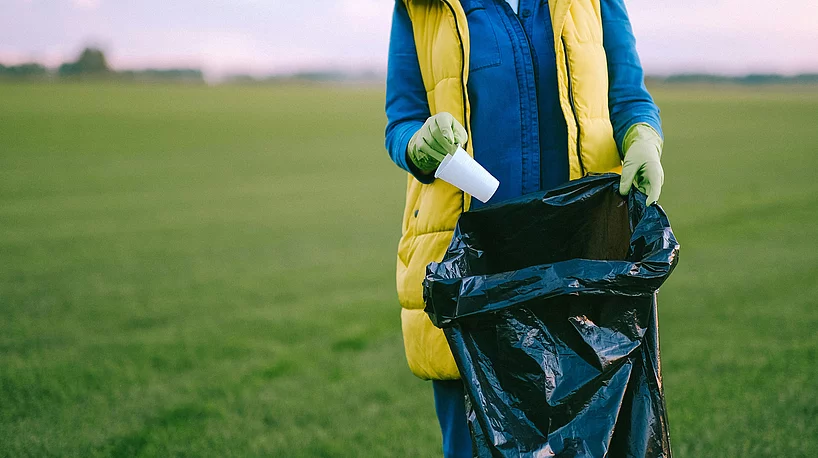 Mensch sammelt Müll